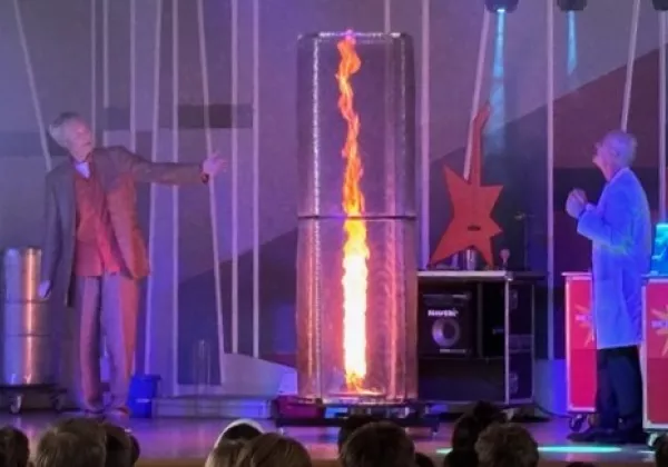 Die Physikanten machen ein Experiment mit Feuer auf der Bühne.